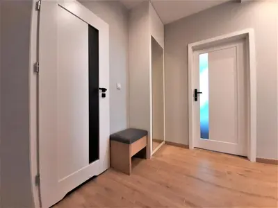 an empty room with a bench and an open door at MOGILSKA Apartments near Tauron Arena Krakow in Kraków