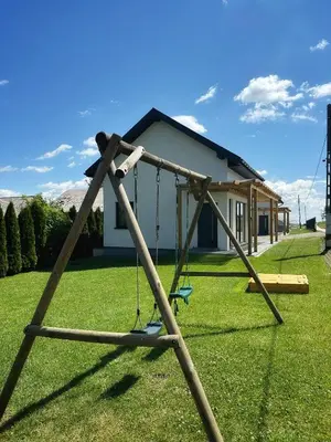 a swing set in a yard with a house at Domek Delux -komfortowe apartamenty, domki w Ojcowskim Parku Narodowym Z Jaccuzi in Wola Kalinowska