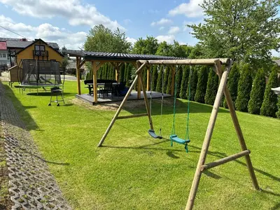a swing set in a yard with a pavilion at Domek Delux -komfortowe apartamenty, domki w Ojcowskim Parku Narodowym Z Jaccuzi in Wola Kalinowska