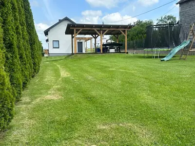 a yard with a slide and a playground at Domek Delux -komfortowe apartamenty, domki w Ojcowskim Parku Narodowym Z Jaccuzi in Wola Kalinowska
