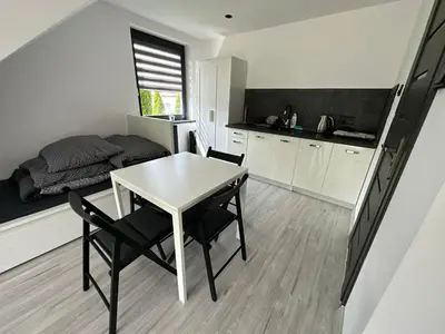 a small kitchen with a table and chairs and a bed at Domek Delux -komfortowe apartamenty, domki w Ojcowskim Parku Narodowym Z Jaccuzi in Wola Kalinowska