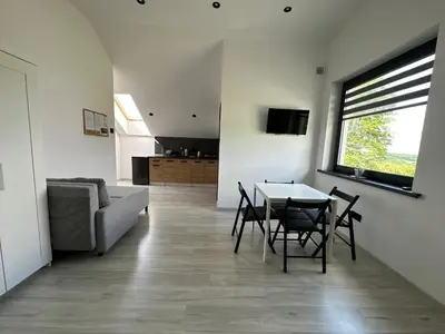 a living room with a table and chairs and a couch at Domek Delux -komfortowe apartamenty, domki w Ojcowskim Parku Narodowym Z Jaccuzi in Wola Kalinowska