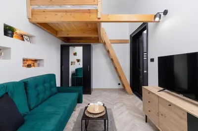 a living room with a green couch and a flat screen tv at Apartment Joselewicza Cracow Kazimierz by Noclegi Renters in Kraków