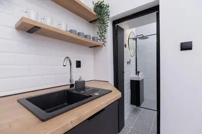 a kitchen with a sink and a shower at Apartment Joselewicza Cracow Kazimierz by Noclegi Renters in Kraków