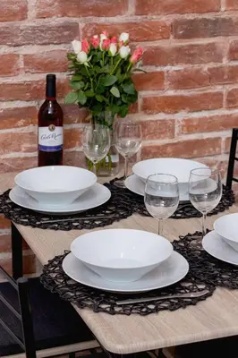a table with plates and glasses and a bottle of wine at Apartment Joselewicza Cracow Kazimierz by Noclegi Renters in Kraków