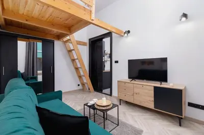 a living room with a blue couch and a tv at Apartment Joselewicza Cracow Kazimierz by Noclegi Renters in Kraków
