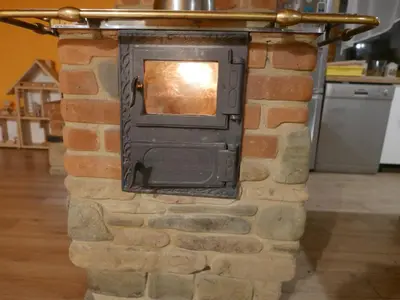 a brick fireplace with a wood stove on it at 22 Kąty in Radziemice
