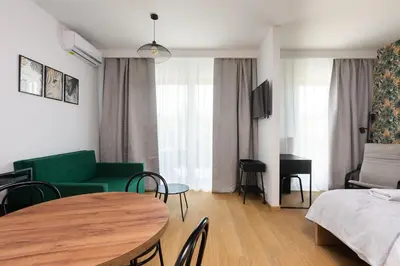 a living room with a green couch and a table at Apartments nearto Main Railway Station in Kraków