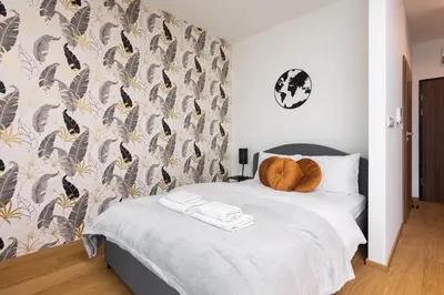 a bedroom with a large white bed with a wall at Apartments nearto Main Railway Station in Kraków