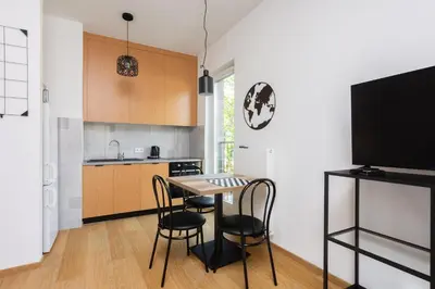 a kitchen with a table and chairs and a tv at Apartments nearto Main Railway Station in Kraków