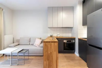 a small living room with a couch and a kitchen at Apartments nearto Main Railway Station in Kraków