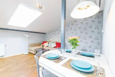 a dining room with a white table and blue plates at Krupnicza Modern Old Town Apartments - by Upstairs in Kraków