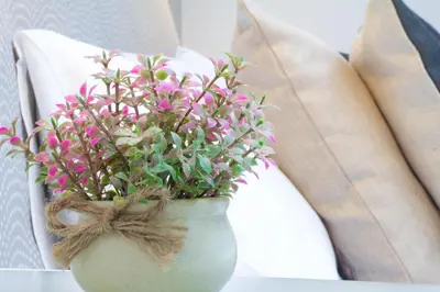 a vase with pink flowers sitting on a chair at Krupnicza Modern Old Town Apartments - by Upstairs in Kraków