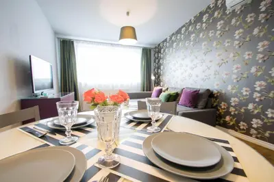 a dining room with a table with plates and glasses at Krupnicza Modern Old Town Apartments - by Upstairs in Kraków