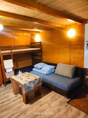 a room with a bed and a table in a cabin at Ranczo Wilka z kominkiem in Chrzanów