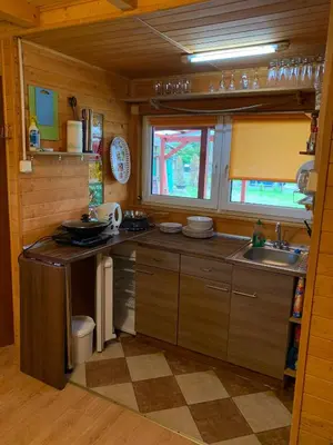 a kitchen with wooden cabinets and a sink and a window at Ranczo Wilka z kominkiem in Chrzanów