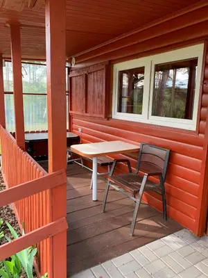 a wooden porch with a table and chairs on it at Ranczo Wilka z kominkiem in Chrzanów