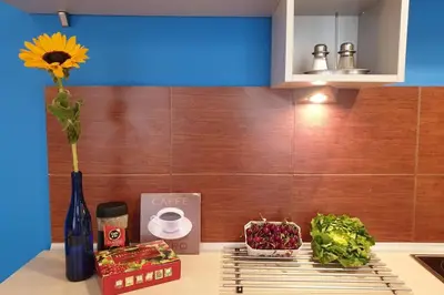 a kitchen counter with a vase with a flower and vegetables at The quiet blue home in the city center! in Kraków