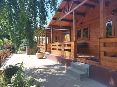 a wooden house with a porch and a courtyard at Domki pod Brzozą in Czarnocin
