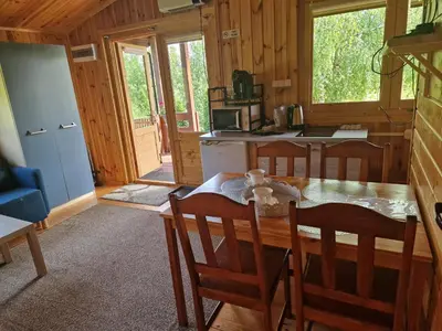 a kitchen and dining room with a table and chairs at Domki pod Brzozą in Czarnocin