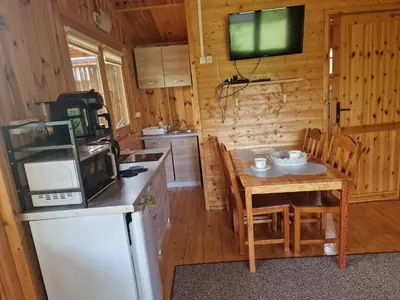 a kitchen with a table and a tv in a cabin at Domki pod Brzozą in Czarnocin