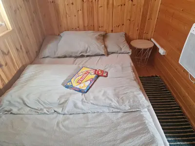 a bed with a book on it in a room at Domki pod Brzozą in Czarnocin