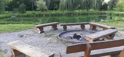a fire pit in a park with two benches at Domki pod Brzozą in Czarnocin