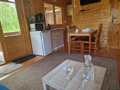 a kitchen with a table with two wine glasses on it at Domki pod Brzozą in Czarnocin