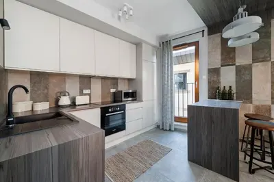 a kitchen with white cabinets and a counter top at Mary&Arte Apartments Browar Lubicz in Kraków
