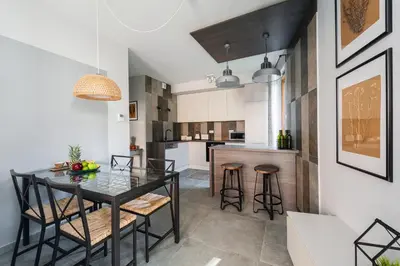 a dining room and kitchen with a glass table and stools at Mary&Arte Apartments Browar Lubicz in Kraków