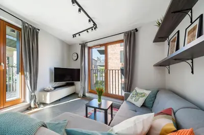 a living room with a couch and a tv at Mary&Arte Apartments Browar Lubicz in Kraków