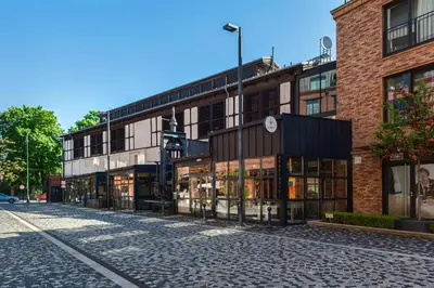an empty street in front of a brick building at Mary&Arte Apartments Browar Lubicz in Kraków