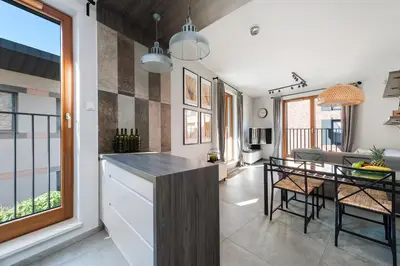 a kitchen and dining area with a table and a dining room at Mary&Arte Apartments Browar Lubicz in Kraków