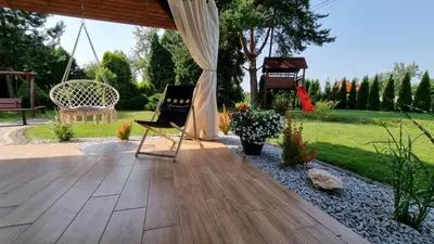 a patio with a swing and a chair and a piano at Apartament Willa Pod Sosnami Zator Przeciszów in Zator