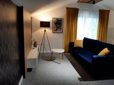 a living room with a blue couch and a table at Apartament Willa Pod Sosnami Zator Przeciszów in Zator