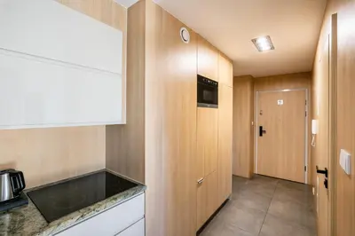 a hallway with wooden walls and a room with a bed at Apartamenty Platinex 3 in Kraków