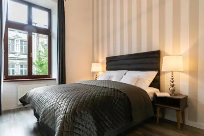 a bedroom with a large bed and a window at be HAPPY Apartments & Breakfast in Kraków