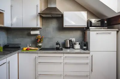 a kitchen with white cabinets and a white refrigerator at be HAPPY Apartments & Breakfast in Kraków