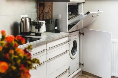 a kitchen with a sink and a washing machine at be HAPPY Apartments & Breakfast in Kraków