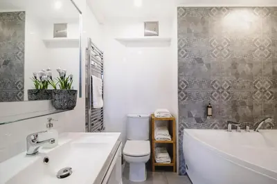 a bathroom with a tub and a toilet and a sink at be HAPPY Apartments & Breakfast in Kraków