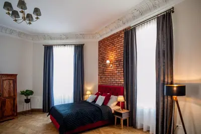 a bedroom with a bed and a brick wall at be HAPPY Apartments & Breakfast in Kraków