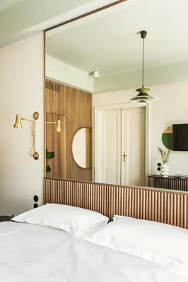 a bedroom with a large mirror above a bed at Angelus Apartments in Kraków