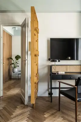 an open door to a room with a desk and a television at Angelus Apartments in Kraków