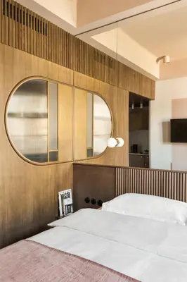 a bedroom with a large bed and a mirror at Angelus Apartments in Kraków