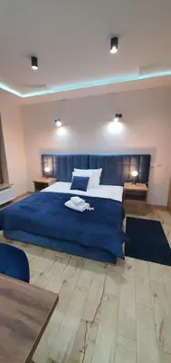 a bedroom with a large bed with a blue blanket at PARK GRZEGÓRZKI in Kraków