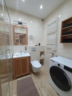 a bathroom with a toilet and a sink and a washing machine at PARK GRZEGÓRZKI in Kraków