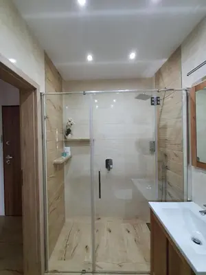 a shower with a glass door in a bathroom at PARK GRZEGÓRZKI in Kraków