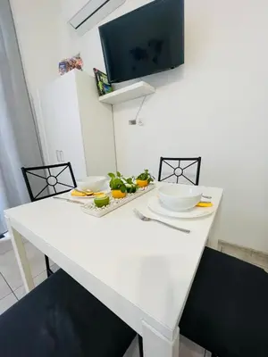 a white table with two chairs and a tv on the wall at Gladiator Noclegi Zator II in Zator