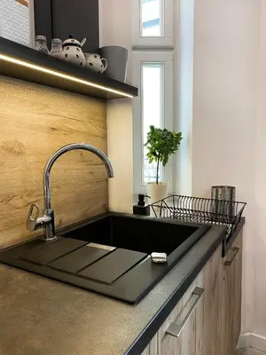 a kitchen sink with a black counter top at Beautiful studio for couples with Air Conditioning - Old Town & Main station in Kraków