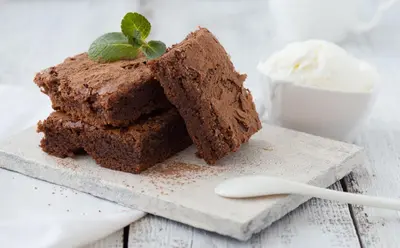 a piece of chocolate cake on a plate with a spoon at Beautiful studio for couples with Air Conditioning - Old Town & Main station in Kraków